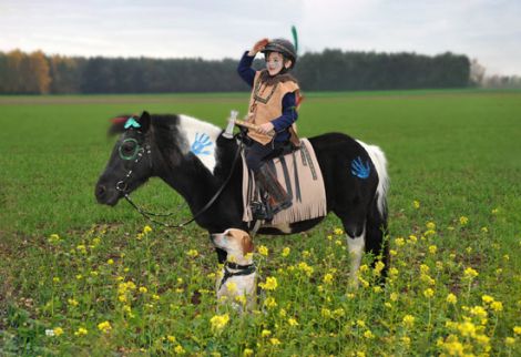 Bild eines Kindes als Indianer verkleidet auf einem Pony